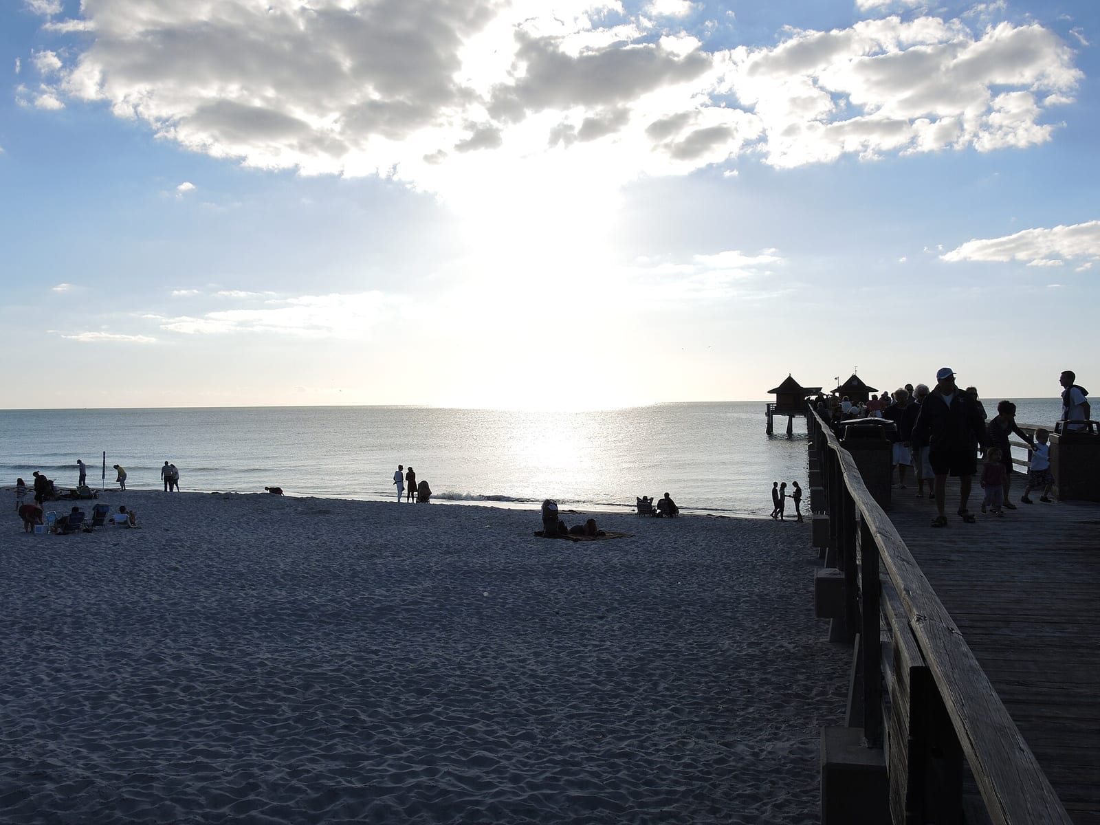 6th Avenue South Beach: sandy beach with pier, ocean, scattered visitors, cloudy sky
