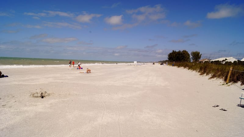 Allison Hagerup Beach: wide sandy beach with scattered beachgoers, dunes, and calm water
