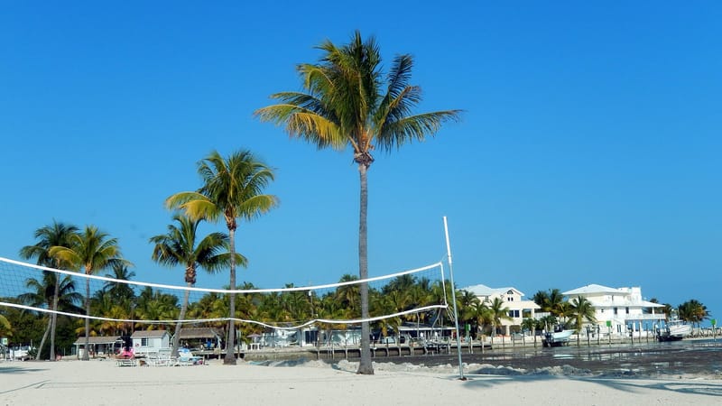 Anne's Beach: sandy beach with volleyball nets, palm trees, waterfront houses