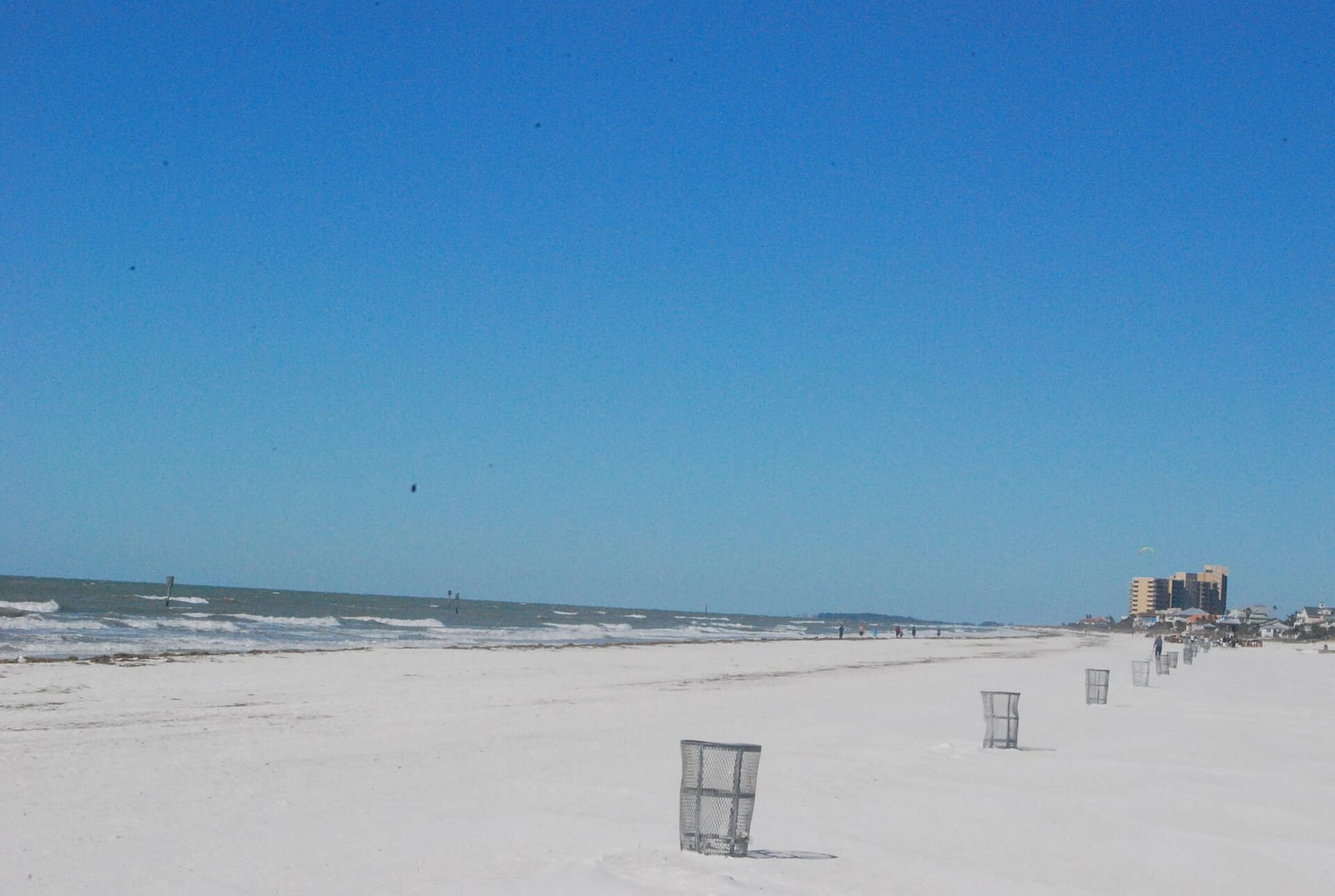 Clearwater Beach: wide sandy beach with lifeguard stands, calm waters, buildings in distance