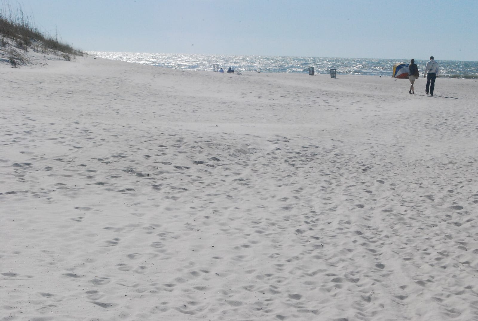 Clearwater Beach: sandy beach with dunes, ocean, and distant beachgoers on horizon