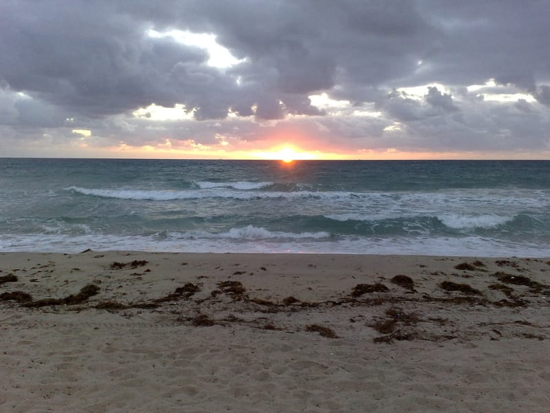 Fort Lauderdale Beach: sandy beach at sunset with waves and dramatic cloudy sky