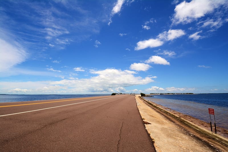Howard Park Beach: wide sandy beach with pier, blue sky, calm water