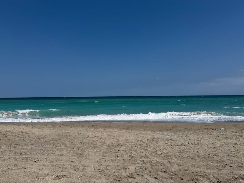 Jensen Beach: sandy beach with turquoise water and white-capped waves under blue sky