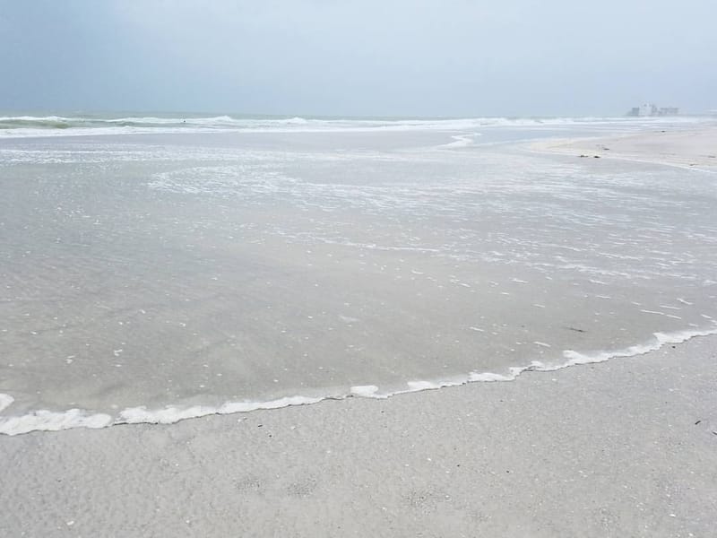 Lido Beach: sandy beach with gentle waves and overcast sky