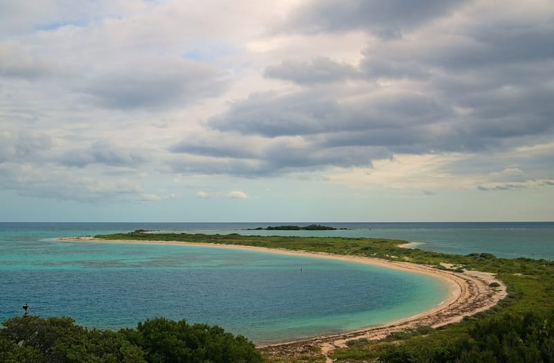 North Swim Beach: curved sandy beach with turquoise water and vegetated island