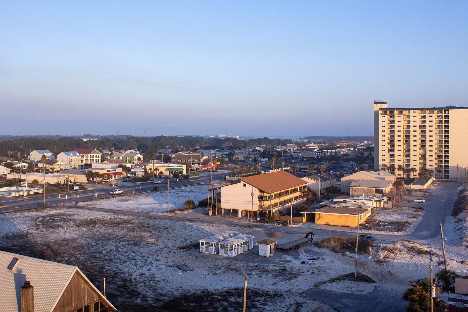 Panama City Beaches: beach town at sunrise with buildings, pier, and residential structures