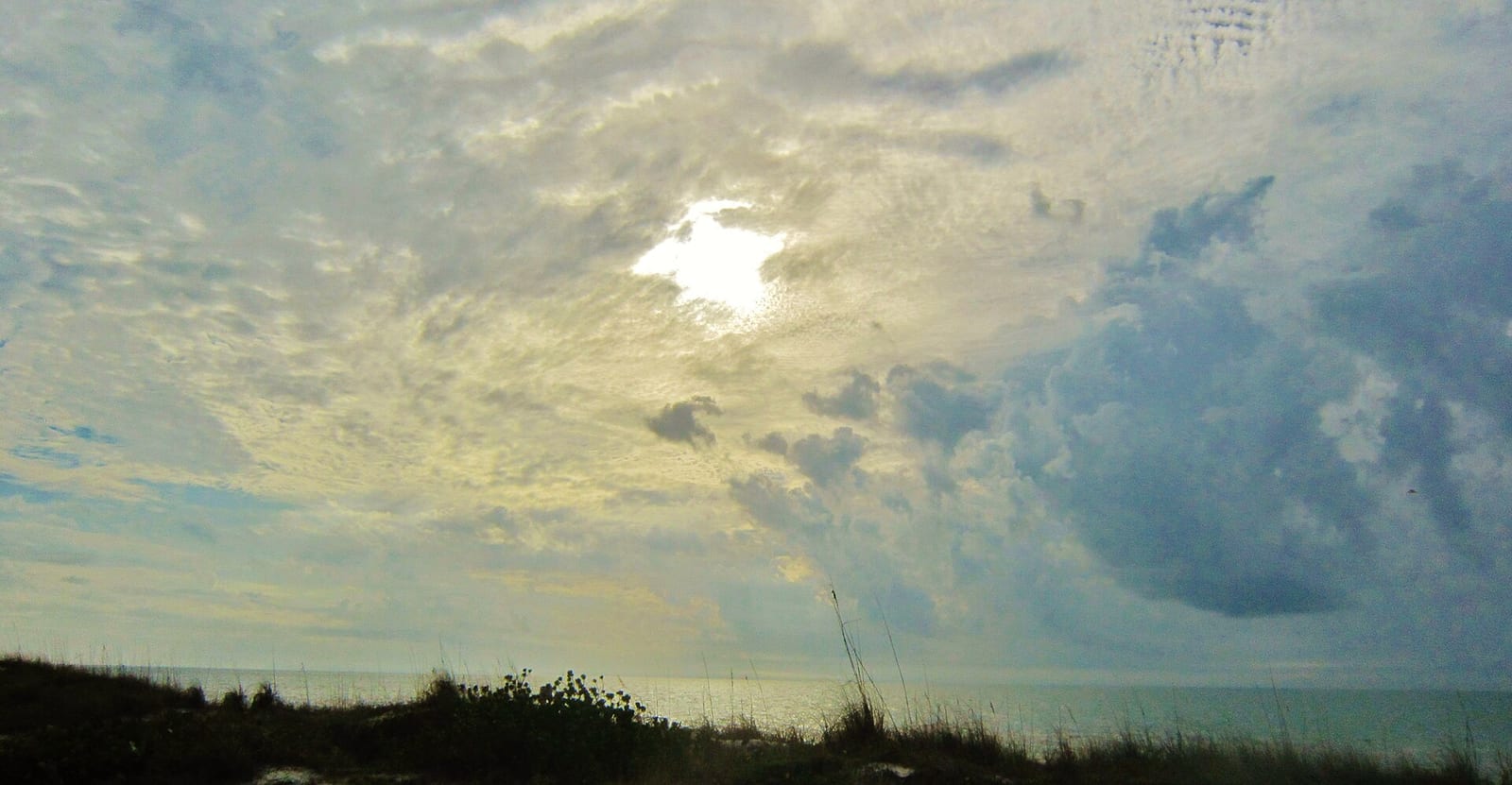 Pasa A Grille Beach: dunes and beach grass with ocean and cloudy sky at sunset