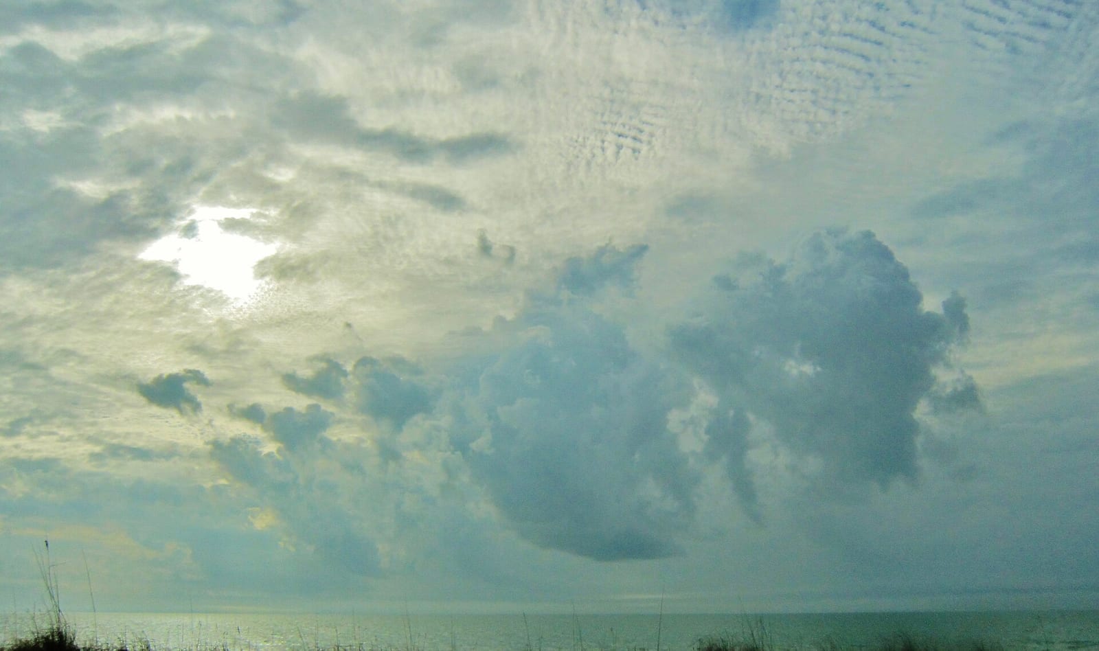 Pasa A Grille Beach: beach shoreline with cloudy sky and calm water horizon