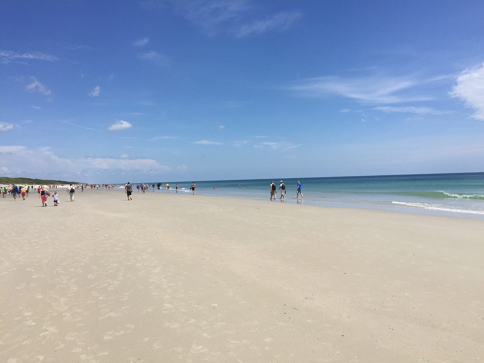Playalinda Beach: sandy beach with ocean, swimmers, and clear blue sky