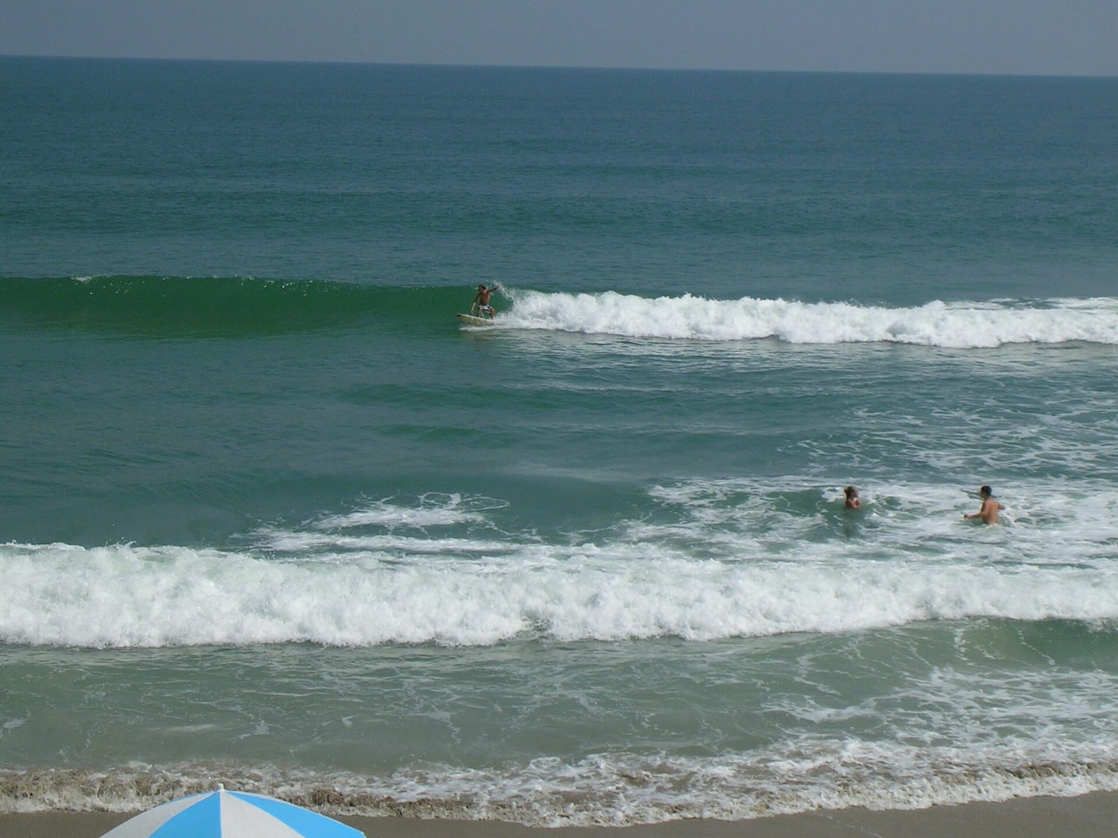 Playalinda Beach: beach scene with surfers, swimmers, and waves near shore