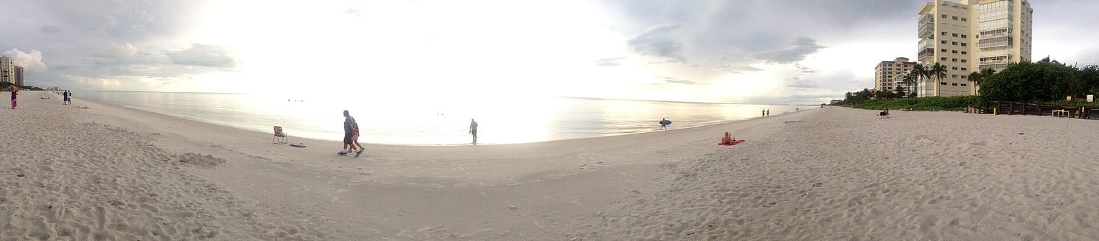 Seabreeze Avenue Beach: wide sandy beach with scattered people, buildings and sky