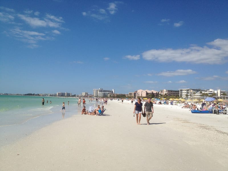 Siesta Key Beach: sandy beach with swimmers, beachgoers, turquoise water, coastal buildings