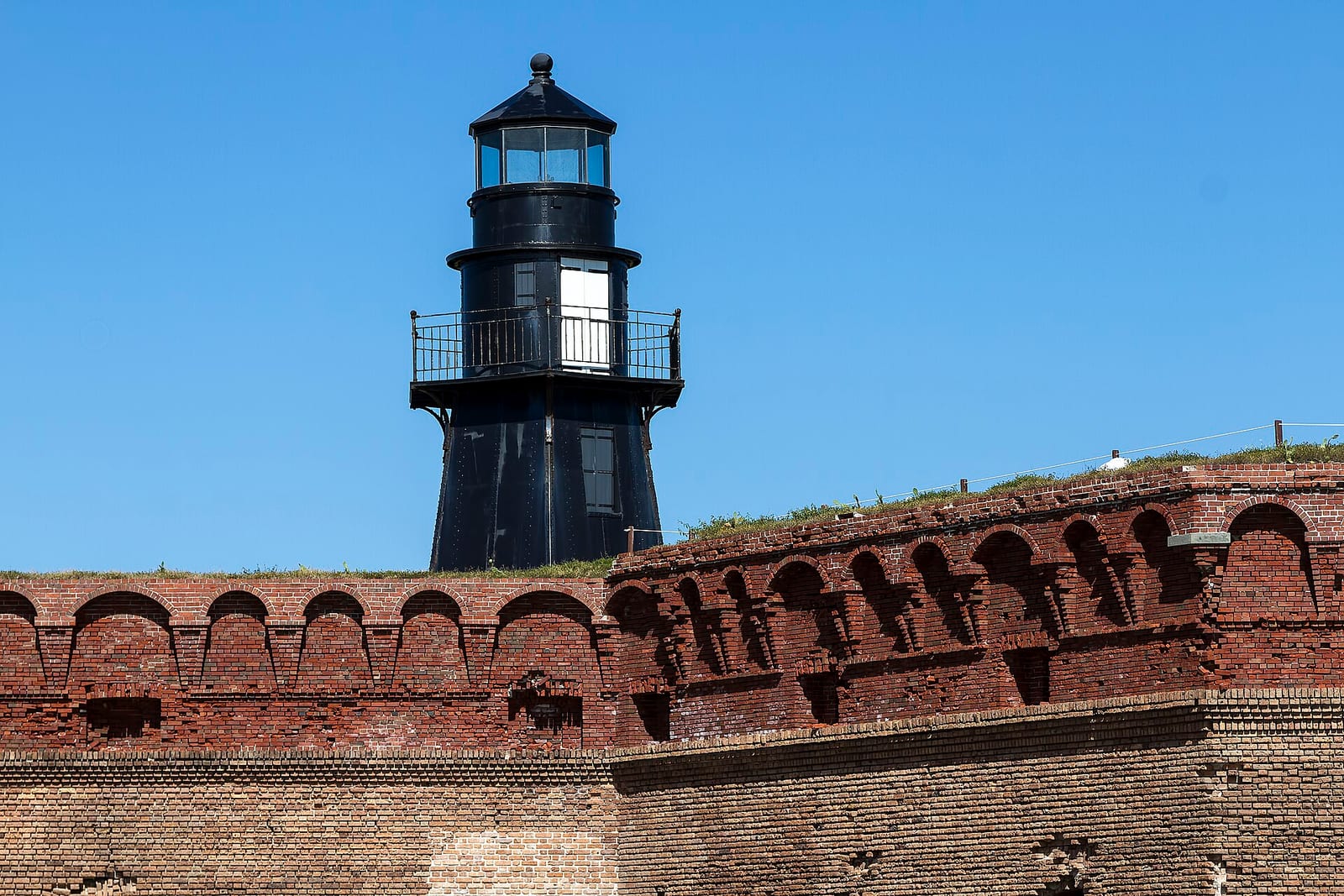 South Swim Beach: lighthouse tower with lantern room atop brick fortification wall