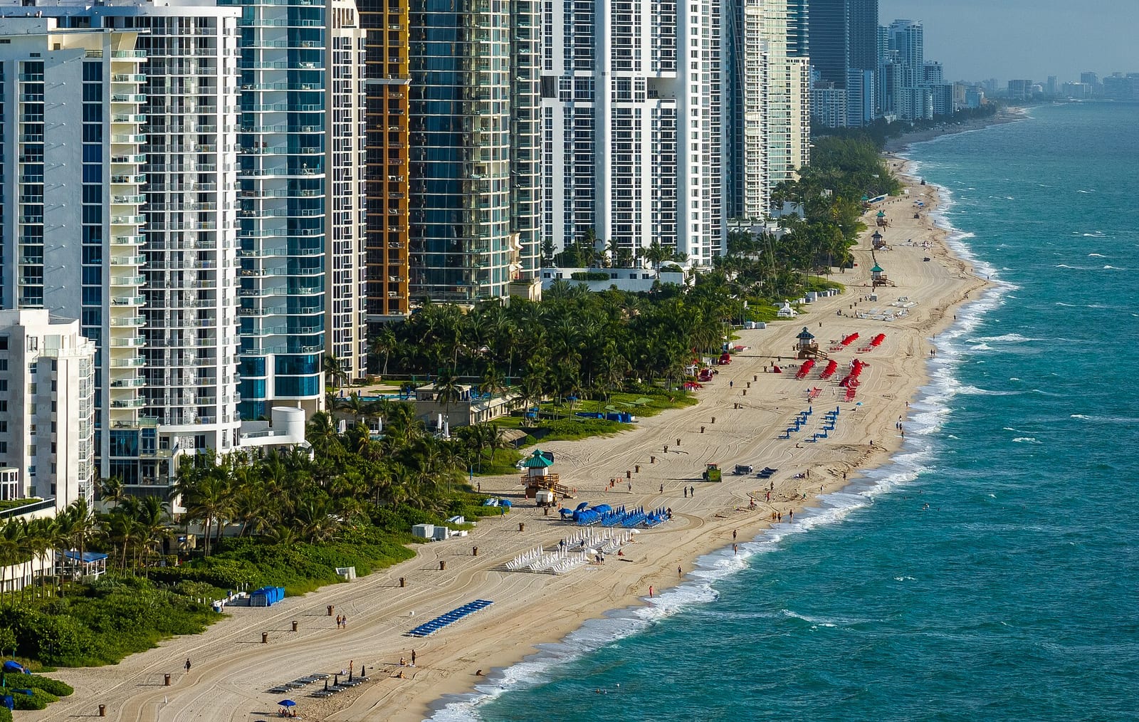 Sunny Isles Beach: high-rise buildings overlook sandy beach with water sports equipment