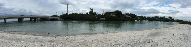 Turner Beach: sandy beach with calm shallow water and distant island with buildings