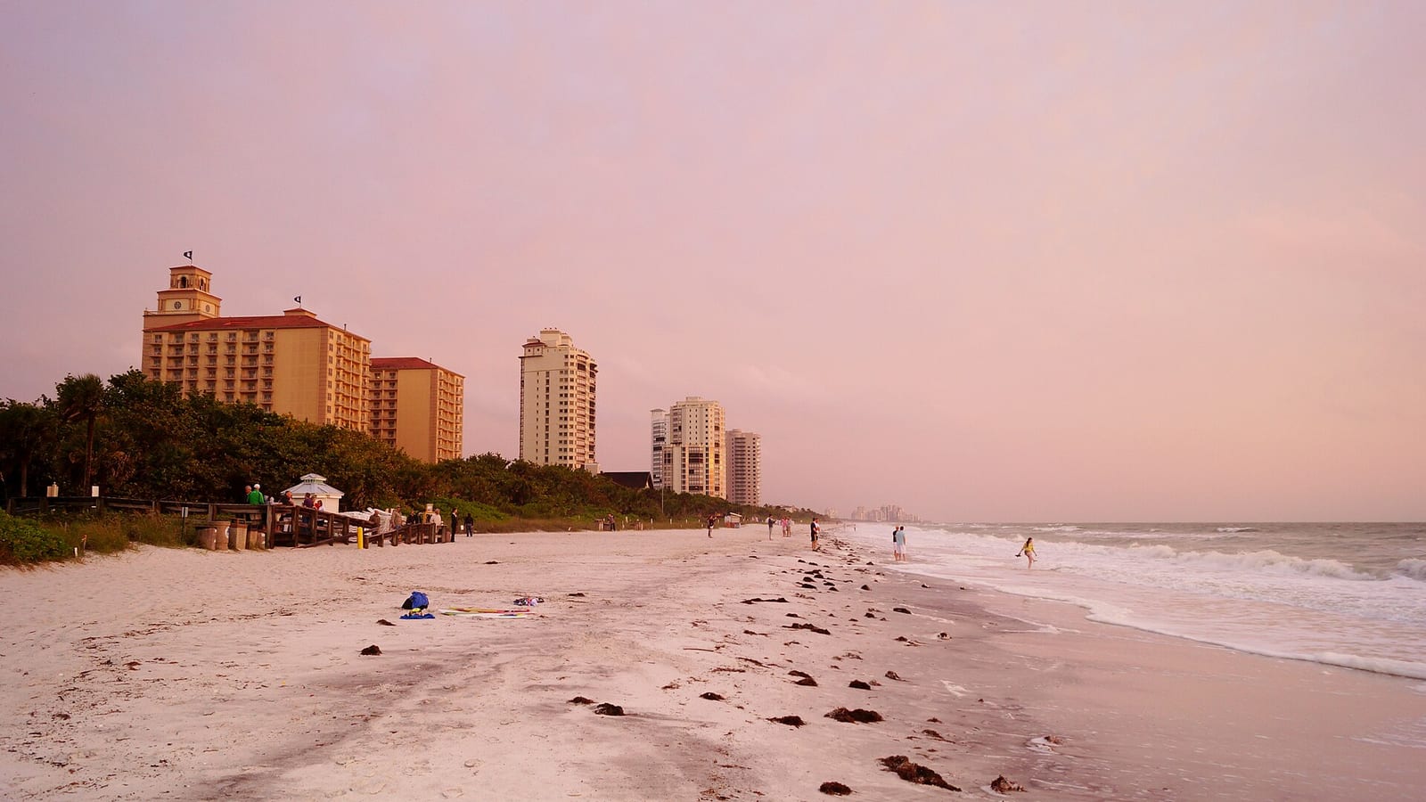 Vanderbilt Beach: sandy beach at sunset with high-rise hotels and ocean waves