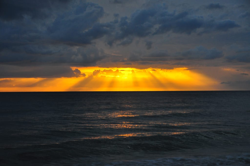 Vanderbilt Beach: dramatic sunset over ocean with golden sky and clouds