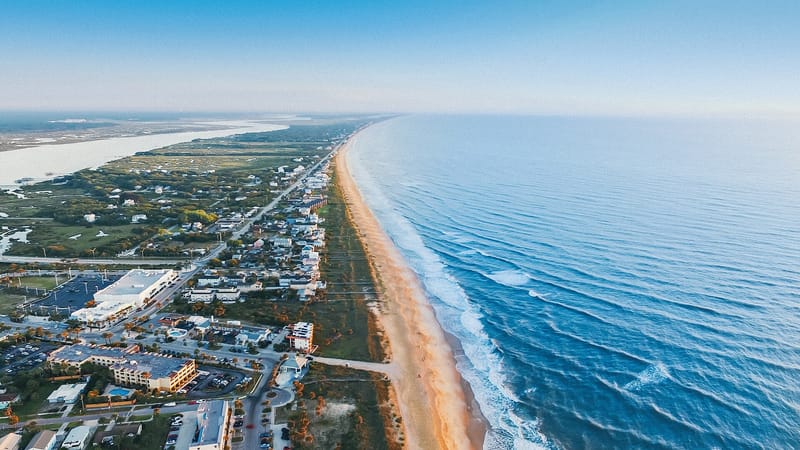 Vilano Point: aerial view of sandy beach with coastal town and ocean waves
